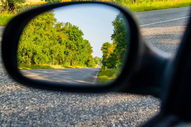 la carretera se refleja en el espejo del coche. - rear view mirror car mirror sun fotografías e imágenes de stock