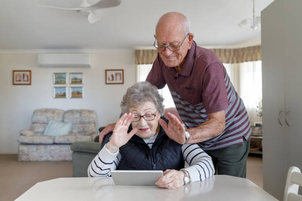 pares australianos sênior que aprendem usar a tabuleta de digitas - idoso na internet - fotografias e filmes do acervo