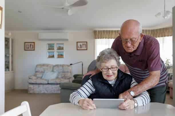 starsza para australijska uczą się korzystać z tabletu cyfrowego - ipad senior adult 70s adult zdjęcia i obrazy z banku zdjęć