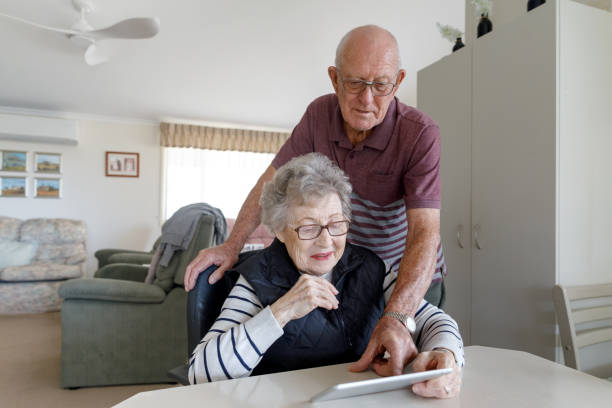 senior australian paar lernen, digitales tablet zu verwenden - senior adult digital tablet domestic life learning stock-fotos und bilder