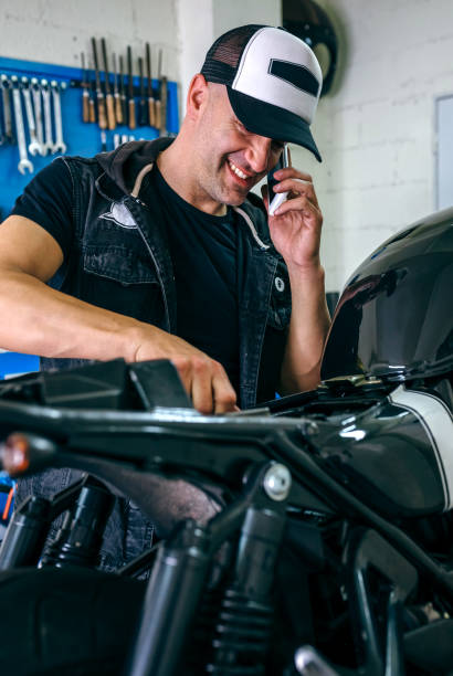 istock Mechanic talking phone while fixing motorbike 1157062706