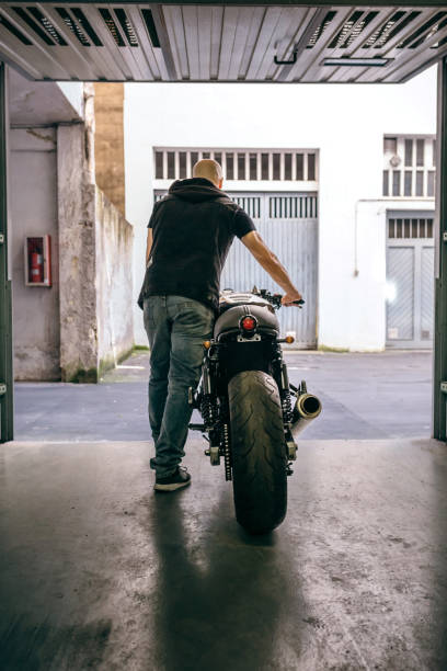 istock Man with custom motorbike leaving the garage 1157062732