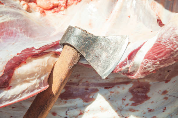 Raw meat with a ax. Cutting meat