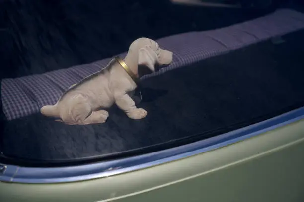 bobblehead dachshund, in german wackeldackel, on the parcel shelf in the car, a popular accessory in the 1970s, copy space