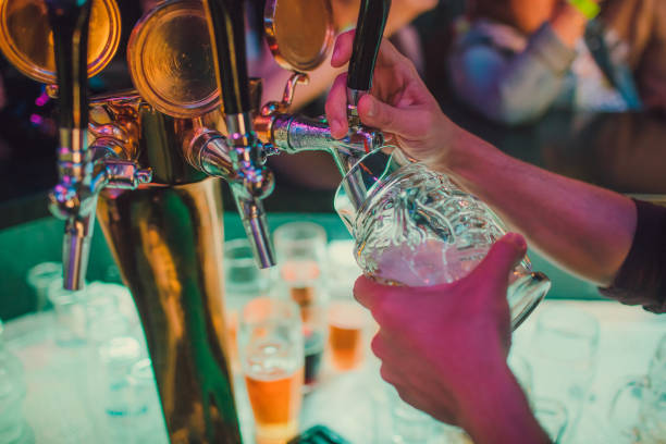 istock Bartender pouring from tap fresh beer into the glass in pub. 1157069740