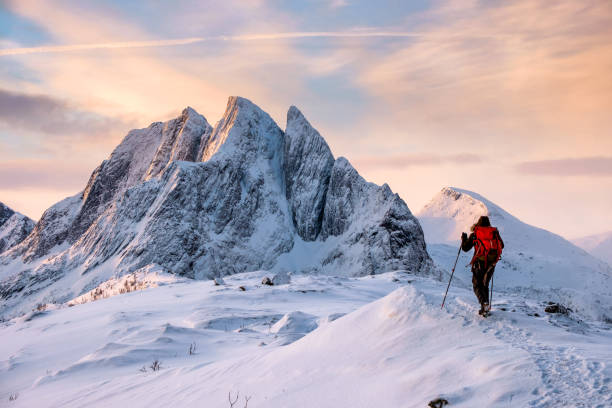 hombre montañero sube en la cima de la montaña nevada - mountain mountain range norway fjord fotografías e imágenes de stock