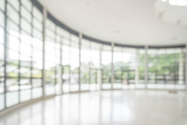 istock Office building or university lobby hall blur background with blurry school hallway corridor interior view toward empty corridor entrance, glass curtain wall, floor and exterior light illumination 1157073538