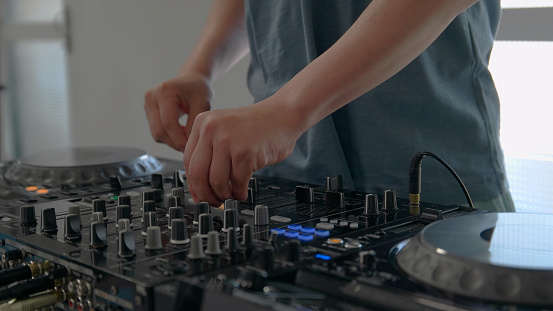 Young man playing with DJ decks at home.