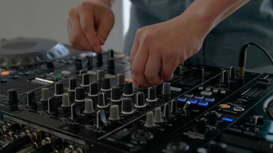 Young man playing with DJ decks at home.