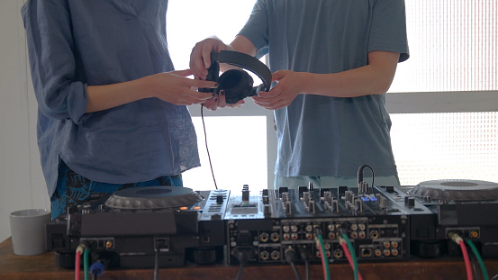 Young couple playing with DJ decks at home.