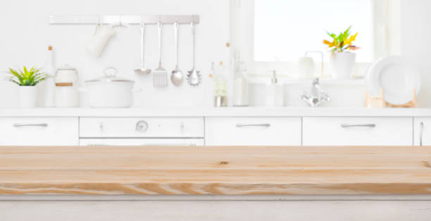 istock Blur kitchen room and window with wood table in front 1157074701