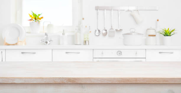 istock Defocused kitchen room and window with wood table in front 1157074785