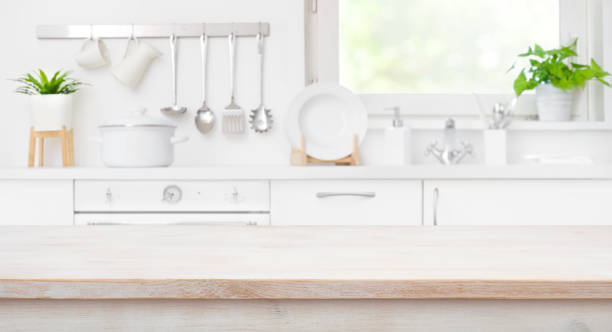 istock Wooden table top on defocused kitchen room and window background 1157075165