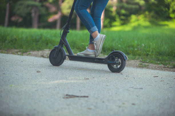 istock Woman riding motor scooter at park 1157075340