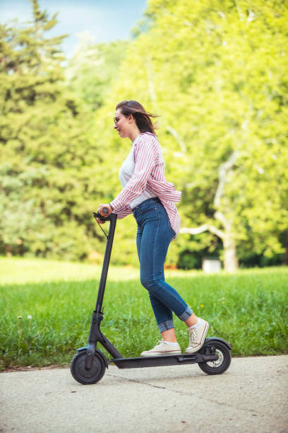 istock Woman riding motor scooter at park 1157075344
