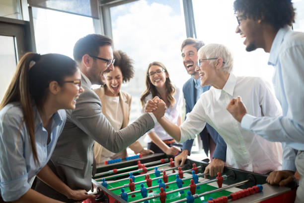 istock Colleagues playing table football in the break. 1157075453
