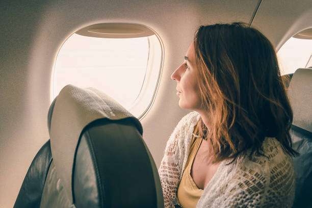istock Girl watching through airplane window. 1157076145