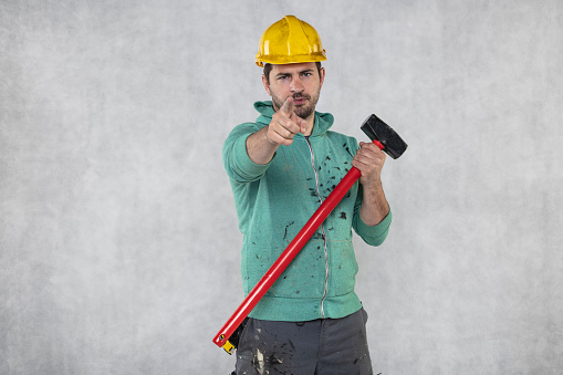 construction worker with a hammer in hand, concept of construction and disassembly, renovation