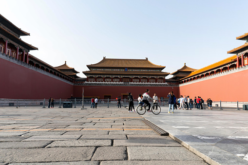 Beijing, China - May 3, 2016: Unidentified woman rides a bicycle at Forbidden City in Beijing.