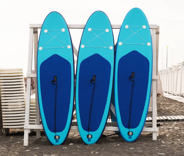 Stand-up paddleboard for SUP surfing in surf station Set of stand-up paddleboard for SUP surfing in surf station on beach paddleboard surfing oar water sport stock pictures, royalty-free photos & images