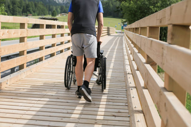 istock Assistant and disabled young man on a wheelchair 1157085421