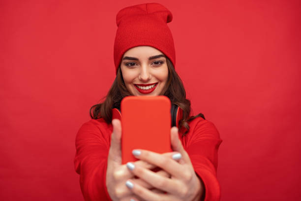 elegante ragazza brillante che si fa selfie con il telefono - red cell foto e immagini stock