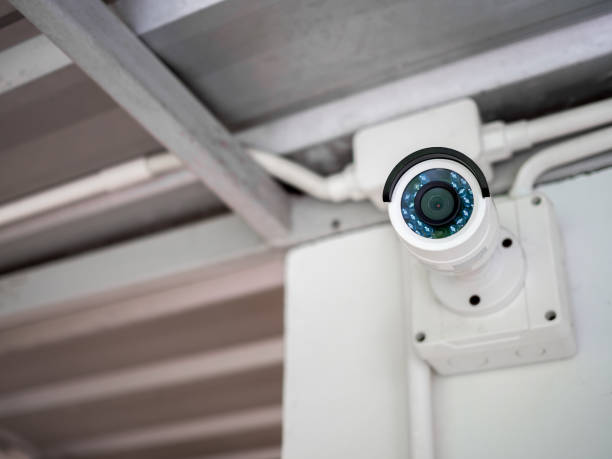 close-up white cctv camera on the wall under the roof - electrical junction box imagens e fotografias de stock