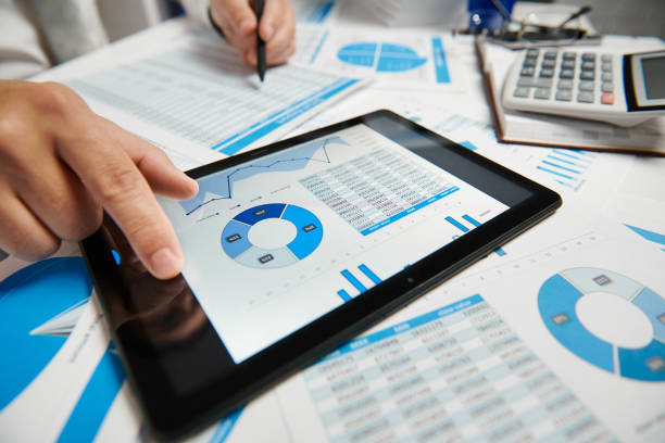 istock Businessman working and calculating, reads and writes reports. Using tablet pc. Office employee, table closeup. Business financial accounting concept. 1157086752