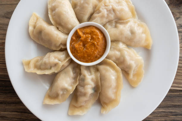 Plate of Nepalese momos Plate of Nepalese chicken momos and its achar (sauce) chinese dumpling stock pictures, royalty-free photos & images