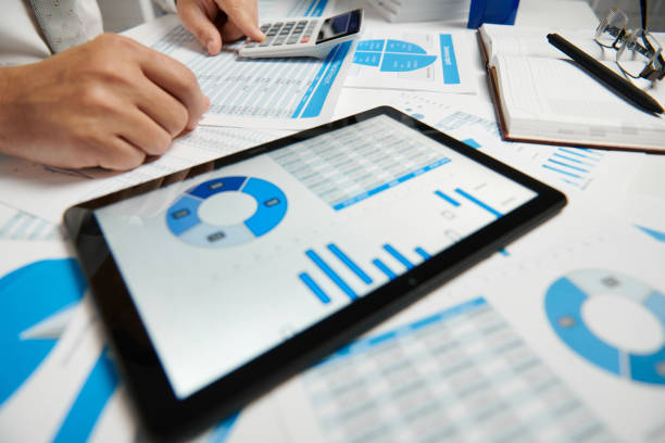 istock Businessman working and calculating, reads and writes reports. Using tablet pc. Office employee, table closeup. Business financial accounting concept. 1157086807
