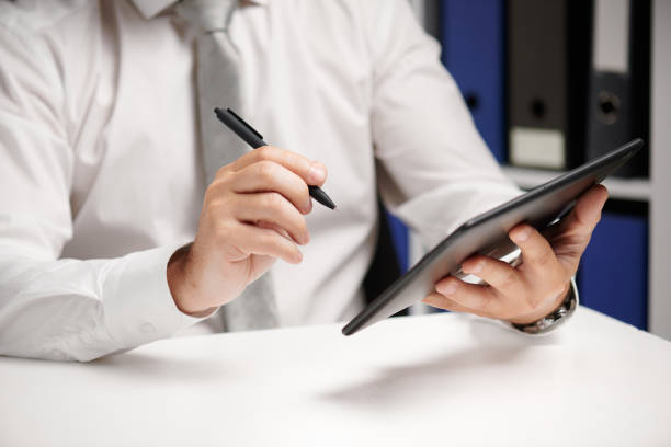 istock Businessman working with tablet pc, calculating, reading and writing reports. Office employee, table closeup. Business financial accounting concept. 1157086925