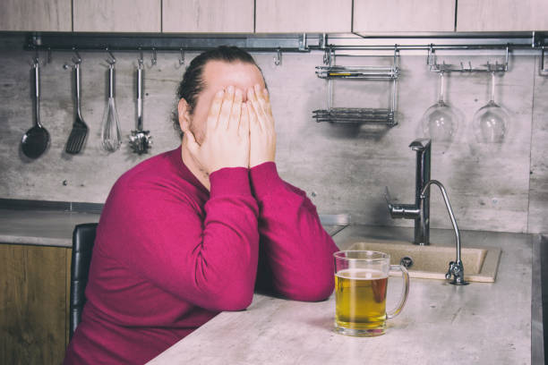 sadness and despair. alcoholism. the man is at home. - remote fat overweight dieting imagens e fotografias de stock