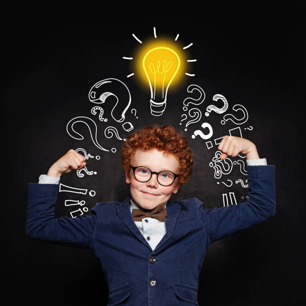 istock Strong child boy with lightbulb on blackboard background. Brainstorming and idea concept 1157088081