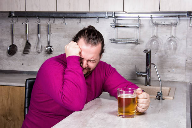 sadness and despair. alcoholism. the man is at home. - remote fat overweight dieting imagens e fotografias de stock