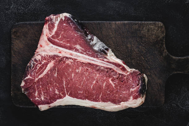 istock Raw T-bone Steak Dry Aged for Grill or BBQ on Vintage Cutting Board 1157088202