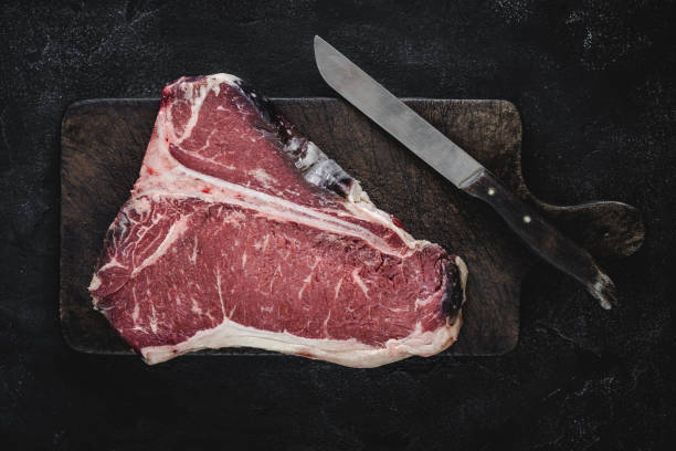 istock Raw T-bone Steak Dry Aged for Grill or BBQ on Vintage Cutting Board 1157088207