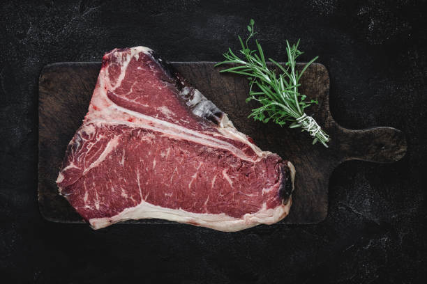 raw t-bone steak dry aged for grill or bbq on vintage cutting board - beef meat t bone steak steak imagens e fotografias de stock