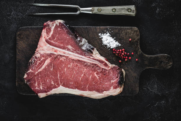 istock T-bone Steak Raw Dry Aged Beef on Vintage Cutting Board 1157088229