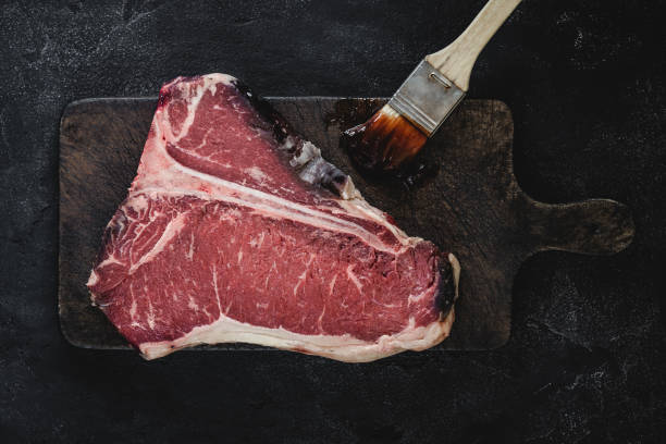 istock T-bone Steak Raw Dry Aged Beef on Vintage Cutting Board 1157088248