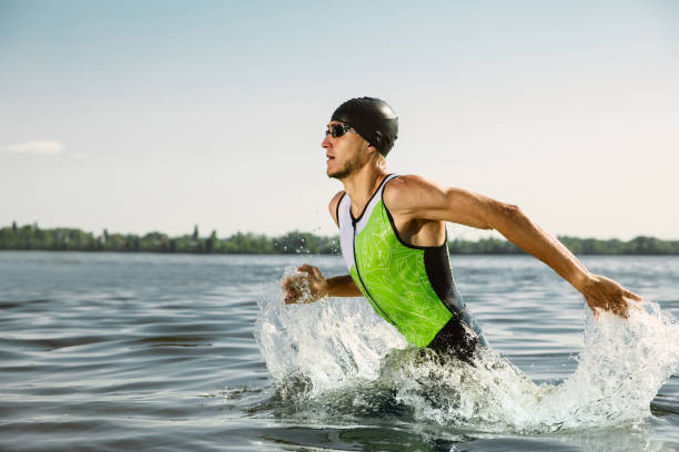 profi-triathlet schwimmen im offenen wasser des flusses - triathlet stock-fotos und bilder