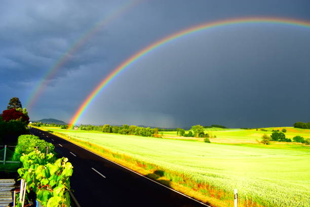 Rainbow during an autumn rain shower over a meadow near the river IJssel close to Zwolle in Overijssel, Netherlands.