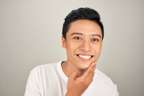 istock Handsome Asian man touching his face close up portrait studio on white background 1157093053