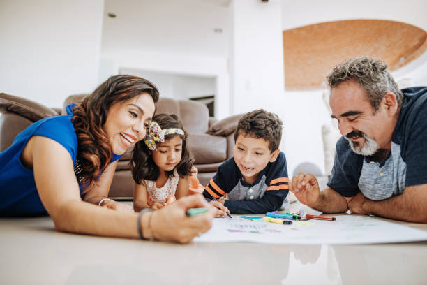 istock Creative Latin parents drawing with children at home and laughing. 1157093345