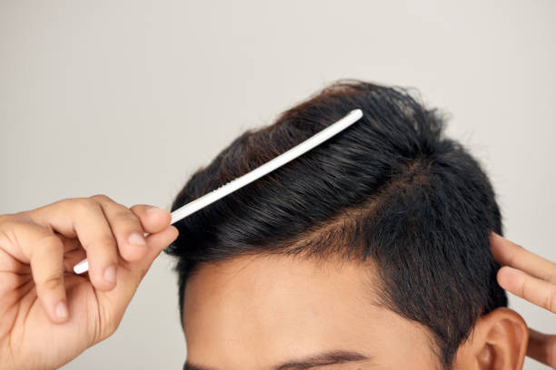 Close up photo of clean healthy man's hair. Young man comb his hair Close up photo of clean healthy man's hair. Young man comb his hair Combing stock pictures, royalty-free photos & images