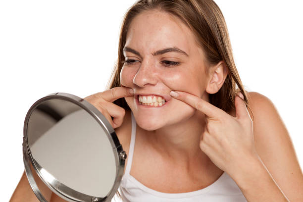 istock young beautiful girl checks her teeth on mirror on white backgeound 1157097889