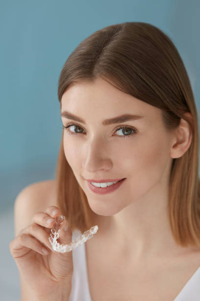 istock Dental care. Smiling woman using removable clear teeth braces 1157100318