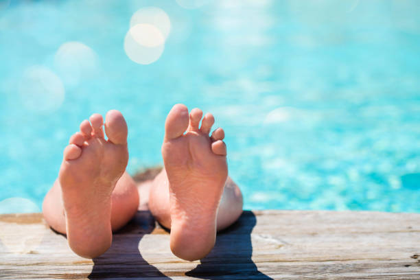istock woman resting by the sunny pool 1157100471