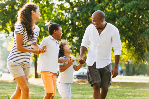 istock Happy couple spending time with their sons in the park 1157101832