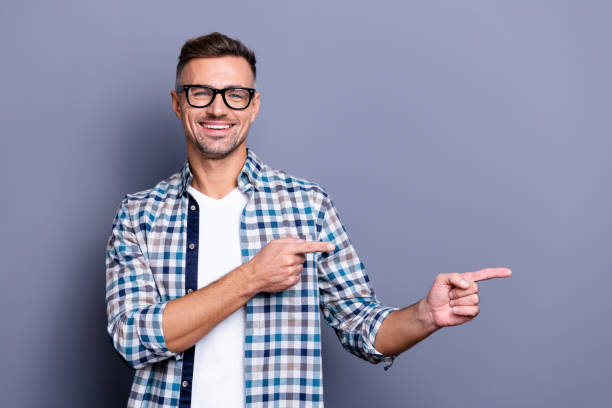 istock Close up photo intelligent attractive he him his guy arms hands indicate empty space cool offer advising buy buyer best price wear specs casual plaid checkered shirt isolated grey background 1157101949
