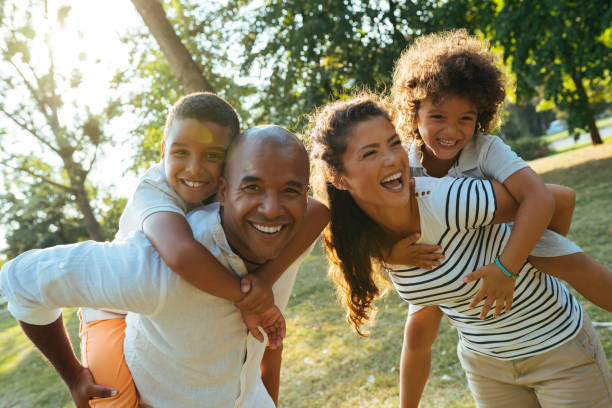 istock Parents piggybacking sons in the park 1157103830